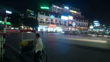 espaço de tempo do noite cidade quang truong dong kinh nghia qui, visto ocupado estrada com passagem carros, motocicletas e ciclistas, edifícios com publicidade sinais video