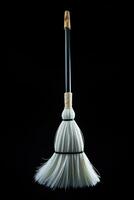 An elegant white broom interpretation isolated on a black gradient background photo