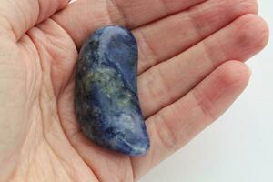 Big blue mineral natural gemstone on hands of woman. Magical stones for esoteric spiritual practice, crystal ritual, witchcraft. Energetical power concept. Healing therapy photo