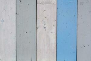 Texture of wood boards with cracked paint of white, beige, grey and blue color. Horizontal retro background with wooden planks of different colors. photo