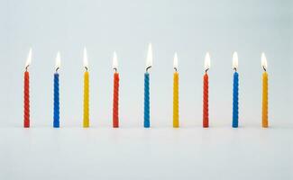 Lit colorful birthday cake candles photo