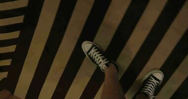 Visão do olhando baixa às homem pernas dentro tela de pintura sapatos indo em uma listrado tapete dentro a corredor hong kong, China video