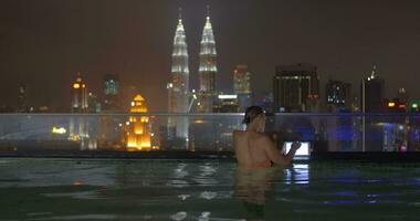 mulher com almofada em telhado piscina dentro Kuala Lumpur, Malásia video