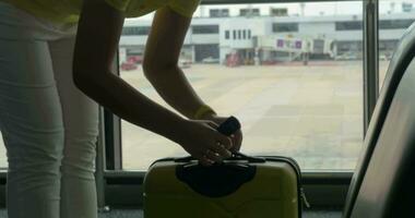 Woman weighing luggage with hand scales video