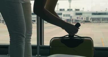 jovem menina dentro Bangkok, Tailândia às a aeroporto pesagem a mala de viagem com bagagem e vai video