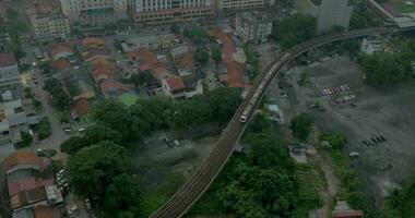 uccello occhio Visualizza di povero quartiere e equitazione treno su linee ferroviarie e poi su per il moderno quartiere con grattacieli Kuala grumo, Malaysia video
