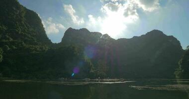 Sun over the islets and touristic boat sailing in Ha Long Bay, Vietnam video