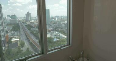 In the city of Bangkok, Thailand young girl in apartment by window taking a bath video