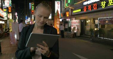 Frau mit berühren Pad im das Straße von Seoul beim Nacht, Süd Korea video