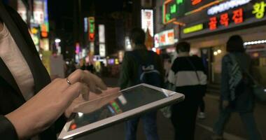 mujer con digital tableta en noche seúl, república de Corea video