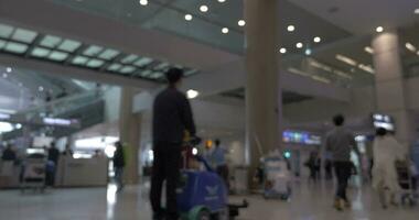 People with baggage and carts in airport terminal video