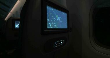 Woman looking at flight path on touchscreen seat monitor video