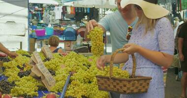 casal escolhendo uvas e Falando com sorrir em ao ar livre mercado Tessalônica, Grécia video