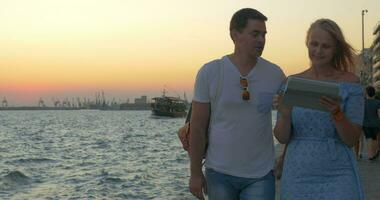 At sunset young couple walking on the seafront in Thessaloniki, Greece video