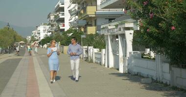 giovane donna e uomo andando danza e utilizzando tavoletta su il strada Salonicco, Grecia video