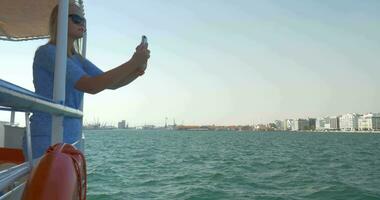 Mädchen Reisen durch Boot im Meer von Stadt Thessaloniki, Griechenland und fotografiert Seelandschaft video
