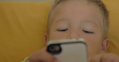 close up shot of little boy playing a game on the smartphone video