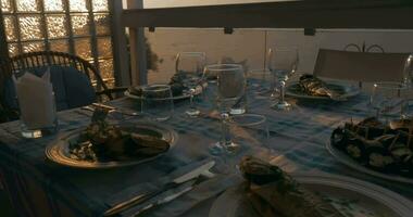 às pôr do sol dentro cidade do peréia, Grécia, jantar mesa servido com cozinhou peixe video