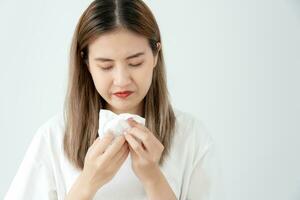 Pollen Allergies, asian young woman sneezing in a handkerchief or blowing in a wipe, allergic to wild spring flowers or blossoms during spring. allergic reaction, respiratory system proble photo