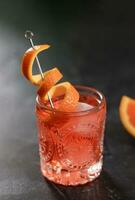 Negroni Cocktail in Retro Glass with Ice and Orange Peel photo