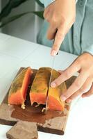 Female Hand Slice Cut Ripe Papaya Using Sharp Knife photo