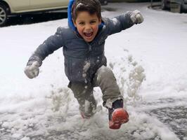 kid enjoys the winter snowy day in playful pose AI Generative photo