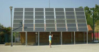 padre tomar imagen de corriendo hijo a lo largo casa con solar paneles en techo el pireo, Grecia video