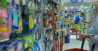 Senior woman is choosing household goods at supermarket with shop basket for cleaning video