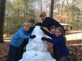 Kids building a snowman in winter day AI Generative photo