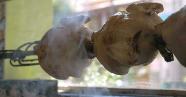 close up shot of cooking appetizing chicken on a spit with a light, fragrant smoke video