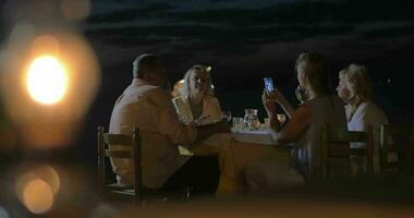 familia sentado a un mesa en noche en ciudad perea, Grecia video