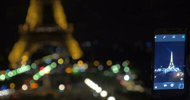 móvil foto de iluminado eiffel torre a noche video