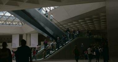 människor trafik i underjordisk hall av louvre pyramid video