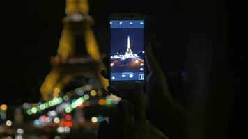 prise coup de Eiffel la tour avec mobile à nuit video