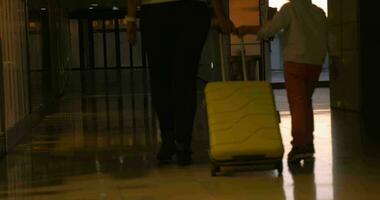 madre e bambino rotolamento valigia a il aeroporto video