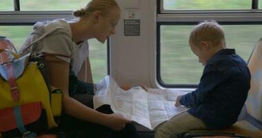mãe e criança com mapa viajando de trem video