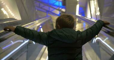 niño consiguiendo piso de arriba en escalera mecánica video