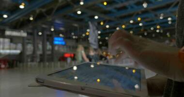 Woman typing on tablet PC in shopping centre hall video