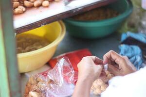 Street food seller of Molen banana served the customers. Molen is a traditional snack food in Indonesia made from flour and banana. photo