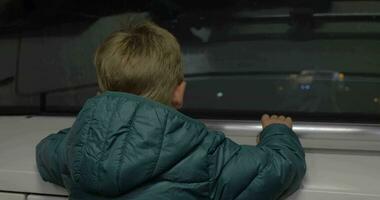 criança olhando às estrada de ferro a partir de comovente metrô trem video
