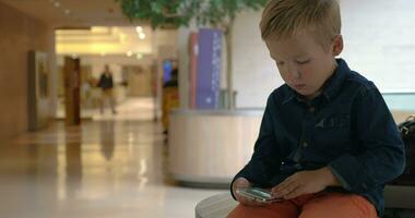 Child flipping photos on cell in trade centre video