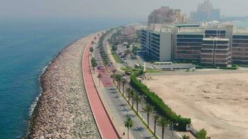 ein Drohne fliegt Über ein Straße entlang das Strand in der Nähe von Dubai, vereinigt arabisch Emirate. Antenne video