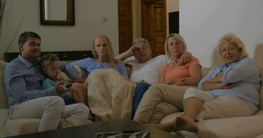 Family in front of TV at home video