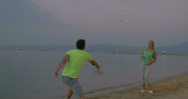 Young couple entertaining themselves with tennis on the beach video