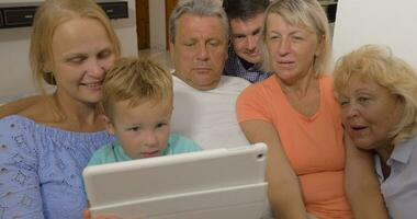 Big family watching something on touch pad video
