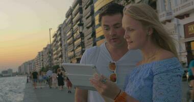 Paar beobachten Tablette am Strand video