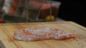 professioneel chef zouten kip filet steak, dichtbij omhoog langzaam beweging video