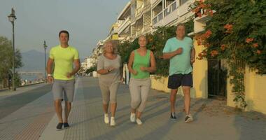 ung och senior människor joggning på solnedgång video