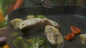 The pan-flip of veggies above the grill. Fresh veggies on the background. Close up slow motion video