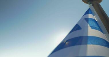 fechar acima Grécia bandeira acenando contra Sol video